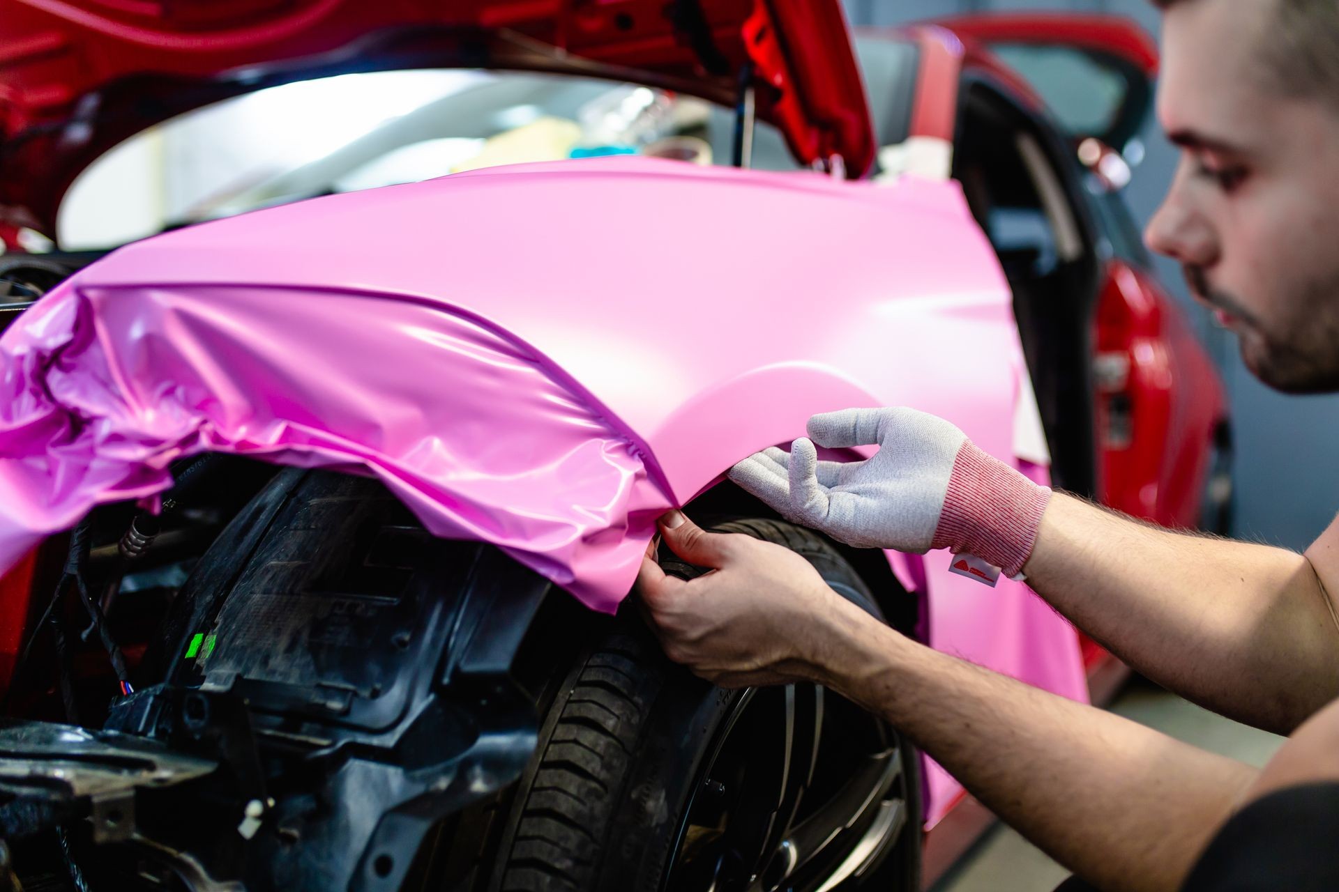 Car wrapping specialist putting vinyl foil or film on car. Selective focus. Car wrapping specialist putting vinyl foil or film on car. Selective focus.